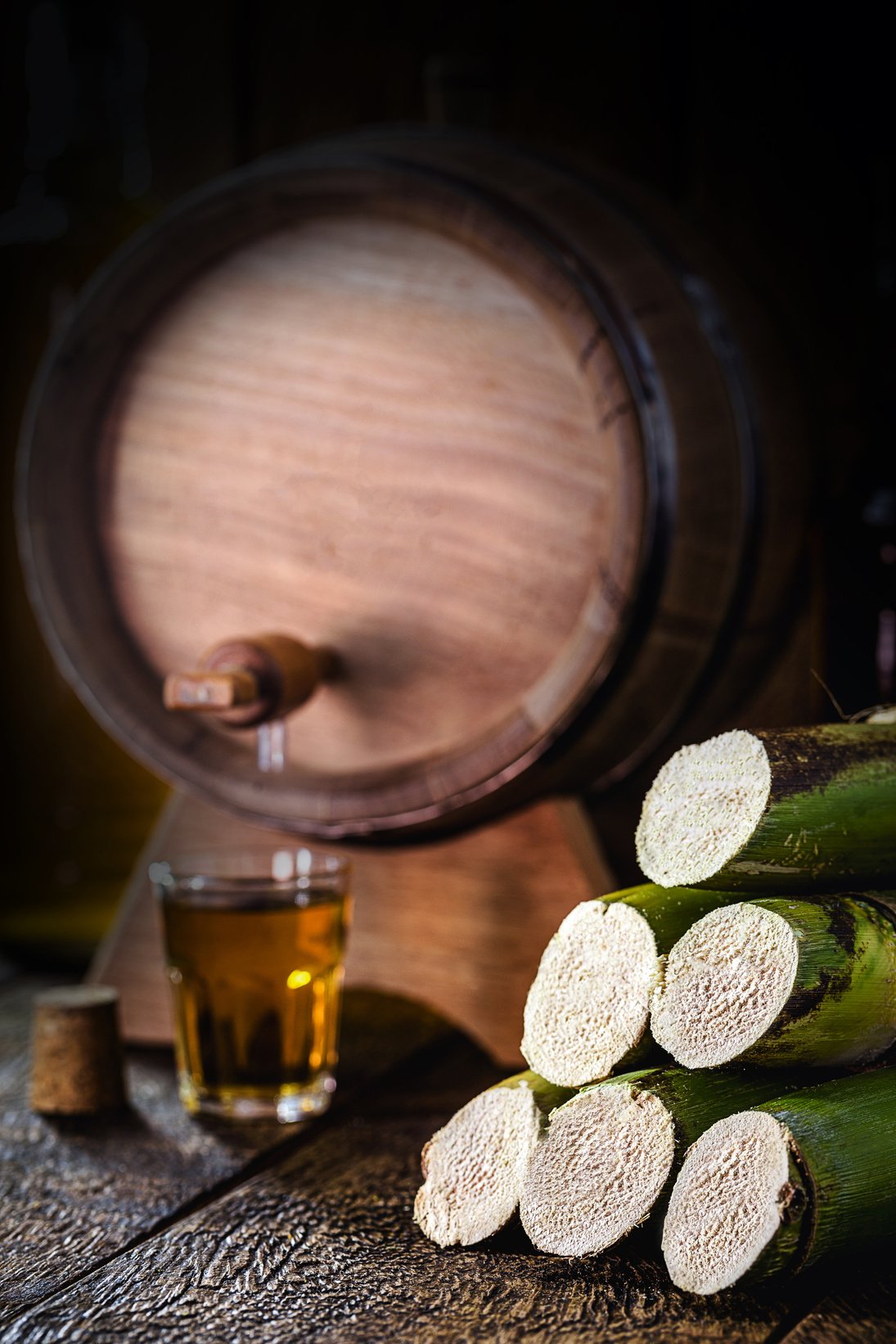 sugar cane used in distilled beverages, rustic wooden setting, still.